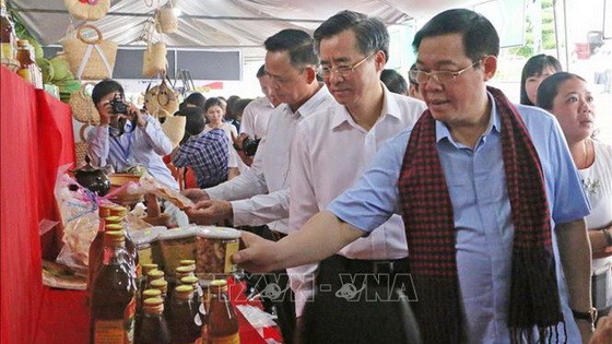 政府副總理王廷惠參觀會議廳外所陳列的農產。（圖源：越通社）