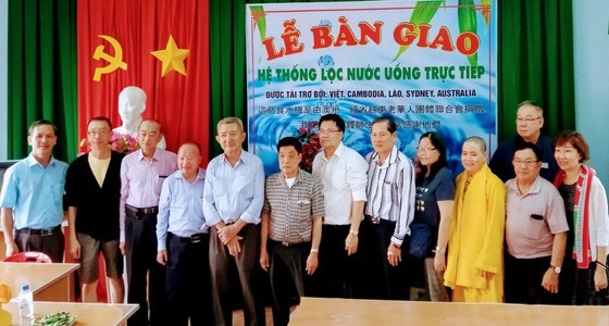 楊怡生（左四），倪耀茂（左六）和李成南 （左七）等澳洲越僑探訪團在移交小學地下水過 濾淨化器儀式上合攝。 