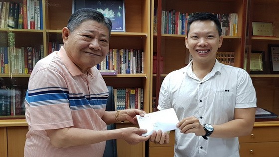 杭慰瑤董事長將贊助贈報活動款項 轉交本報執行編輯林曉東。