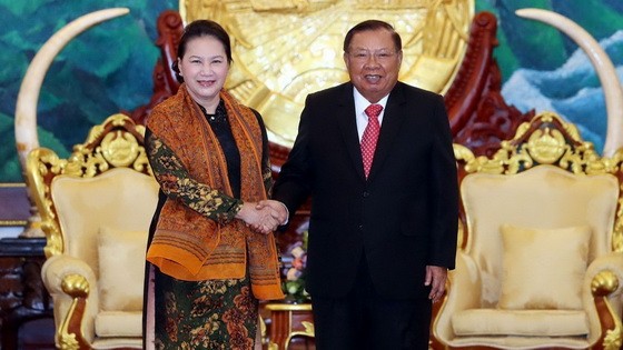 國會主席阮氏金銀與老撾總書記、國家主席本揚握手。（圖源：越通社）
