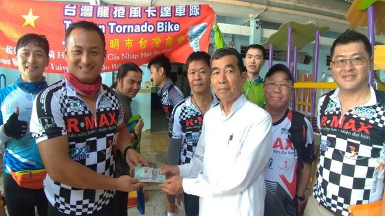 車隊代表把之前所募捐到的1億6900萬元善款與物資轉交給教養院的負責人。