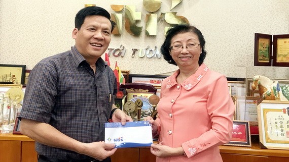 平仙公司副總經理陳芳珍(右)把贈報款項轉交給本報主編阮玉英(紅藍)。