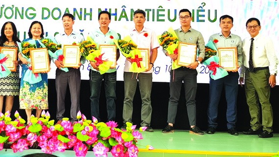 第八郡企業協會副主席、華人企業家麥漢強(右一)向新會員頒發會員證書。