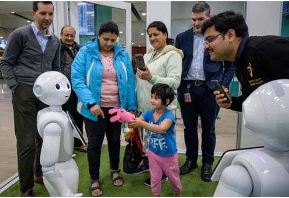 人們與人形機器人互動。（圖源：新華社）