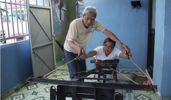 陳煌明研究製造出讓孩子們鍛煉手力的一台機。圖片中是陳煌明與韋氏姮。