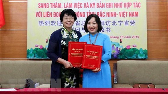 北寧省勞動聯團副主席阮氏雲霞（右）與中國浙江省總工會副主席張衛華簽署對外關係合作備忘錄。（圖源：越通社）