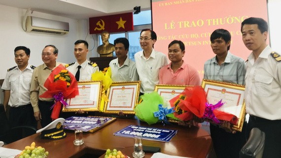 市人委會常務副主席黎清廉（右四）向貨輪沉沒救援組頒發獎金。（圖源：文平）