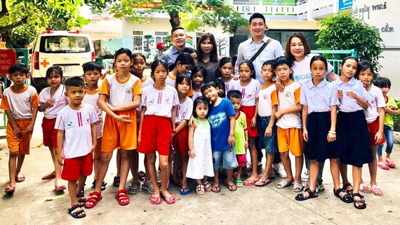 台商代表團與該中心主任黃小香和孤兒合照留念。