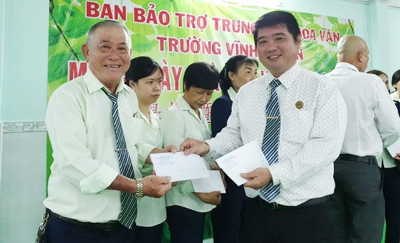 董事長陳金泉（右）頒發獎金給老師、員工。