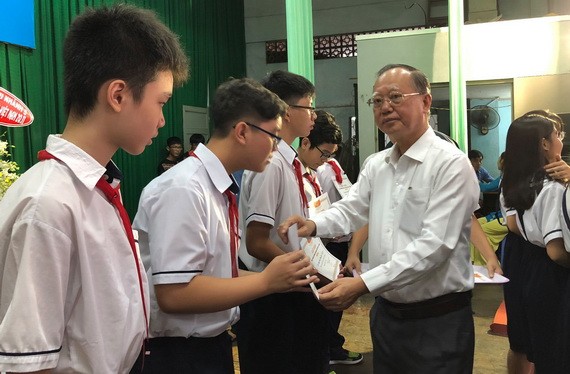 穗城會館理事長盧耀南向郡級優秀生頒獎。