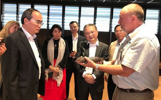 阮善仁同志（前左）參觀 Taronga 動物園，並聆聽該動物園專家介紹罕見鹹水鱷魚的特性。（圖源：喬峰）