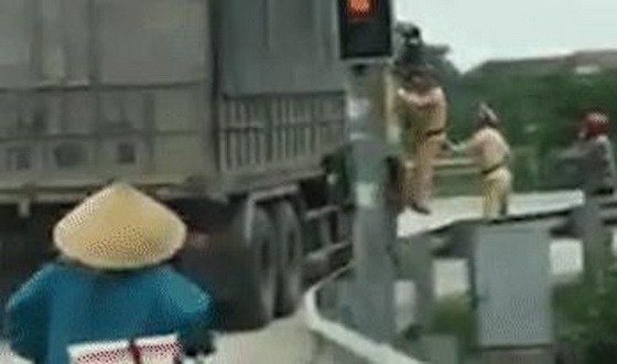 卡車司機不執行號令，故交警跳上抓住車門，堅決要求司機停車。（圖源：視頻截圖）