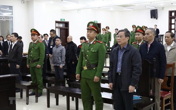 各被告人、法警及庭上所有出席者站立著聽取審判長宣讀判決書。（圖源：越通社）