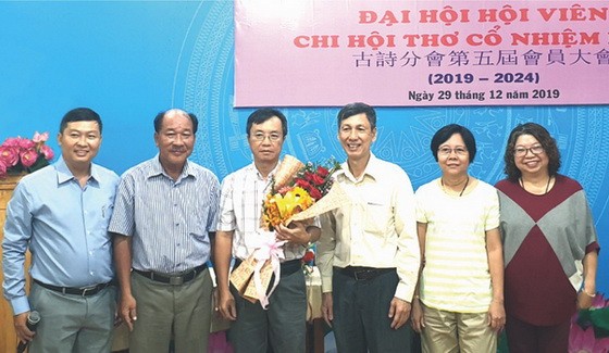 市各民族文學藝術協會辦公室主任張四妹 (右一)代表協會向新一屆執委送花祝賀。