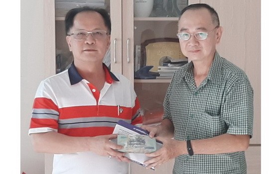 本市台商會會長鄭文忠（左）將歲暮濟貧款項交予本報編委兼編輯部主任范興代領。