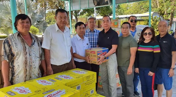 熱心人士劉根全(中右)代表眾友把食用品轉贈給該中心主任阮文石。