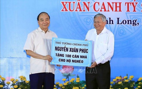阮春福總理（左）贈送永隆省窮人100間住房。（圖源：越通社）