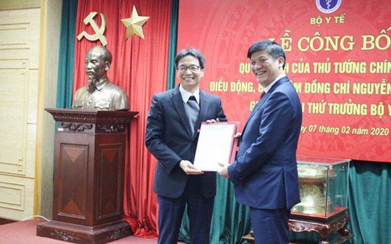 衛生部副部長阮清隆（右）從政府副總理、衛生部黨幹事處書記武德膽手中接過人事委任《決定》。（圖源：Chinhphu.vn）
