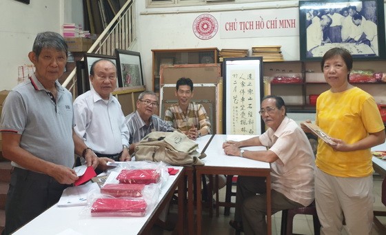 李克柔(左一)，張路(左二)，黃獻平 (左三)，李松年(右二)在市各民族文學藝術會址為聯展準備工作。