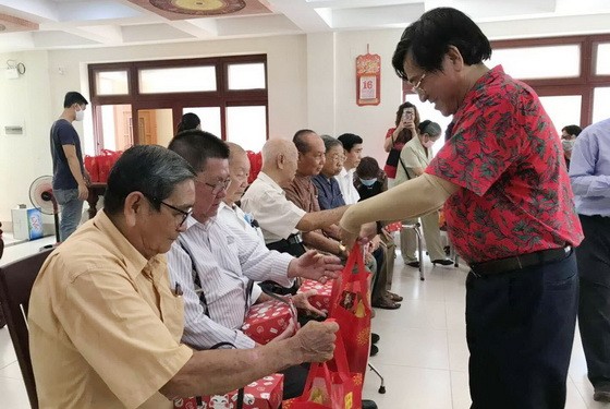 何氏宗祠理事長何冠忠向高齡宗親及麥氏顧問派發紅包和禮物。