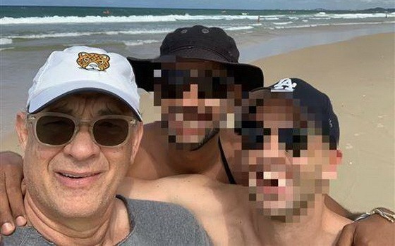 湯姆‧漢克斯(左)在海灘和影迷合影。（圖源：互聯網）