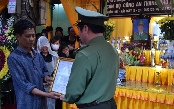 承公安部長之託，寧平省公安廳廳長范文山大校向執行任務中殉職的丁文貴大尉家屬頒授少校警銜追封《決定》。（圖源：泰伯）