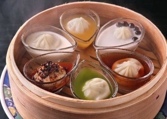 小籠包被放置在玻璃容器中，還浸泡著“珍珠椰奶”、“芒果汁”、“豆漿”、“綠茶”、“烏龍茶”以及“麻辣湯”的湯汁當中。（圖源：互聯網）