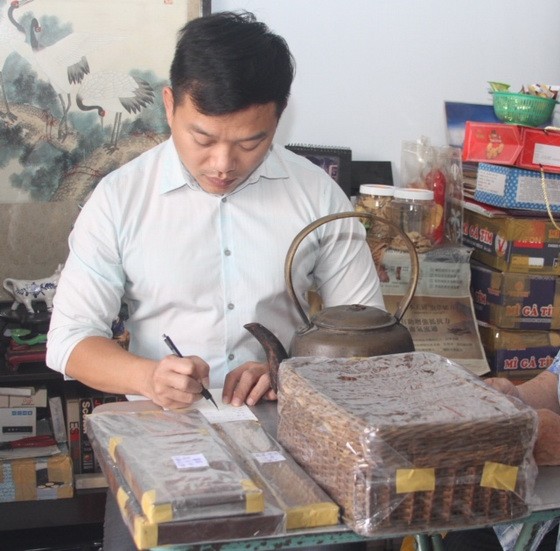 作者在整理陶女士捐贈“西堤華人文化陳列室”的文物。