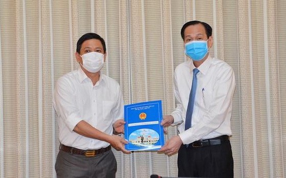 陳春田同志（左）從市人委會常務副主席黎清廉手中接過人事委任《決定》。（圖源：越勇）