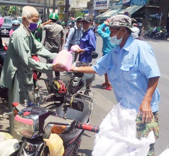 華人商販應氏蓮託“摩的”司機派發救濟品。