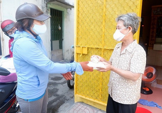 舊邑郡第五坊婦女會主席陳瑞竹山（左）上門給阮氏六大娘送飯菜。