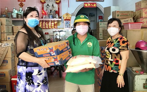 梁柳嬋（左）與弟婦向勞動人家贈送禮物。