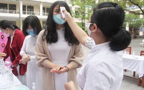 學生進校前都先要量體溫。（圖源：教育報）