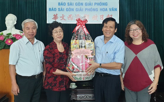 《西貢解放報》副總編輯、本報主編阮玉英(紅藍)與記者等親切接待代表團。