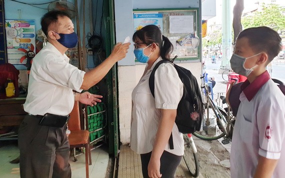 學生進校門時接受體溫測試。