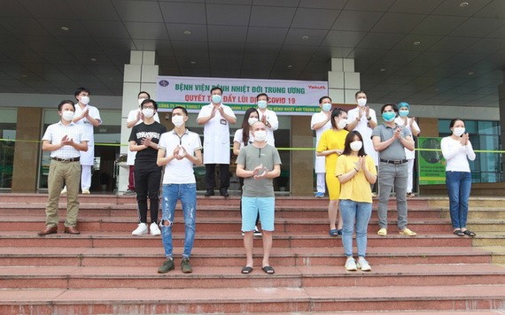 5月5日，在中央熱帶病醫院收治的11 名新冠肺炎患者痊愈出院前與醫護人員合照。（圖源：越通社）