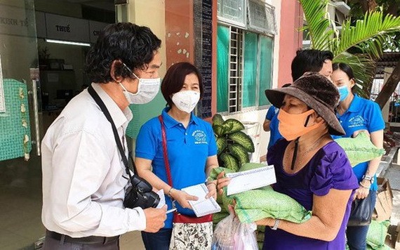 《西貢解放報》社會慈善-讀者工作組人員在抗疫期間向受影響的民戶派發輔助現金、大米和日需品。（圖源：孟和）
