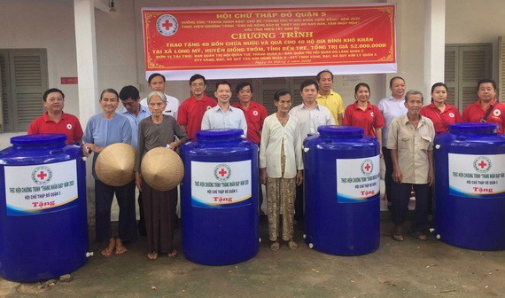第五郡紅十字會和穗城、溫陵會館代表向貧戶移交水塔。