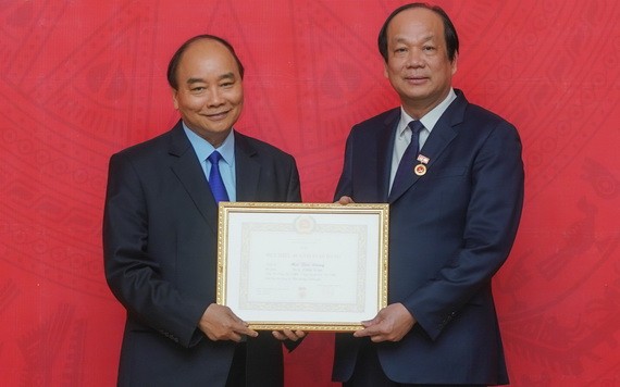 政府總理阮春福（左）向黨中央委員、政府辦公廳黨委書記、辦公廳主任梅志勇部長頒授40年黨齡紀念章。（圖源：光孝）