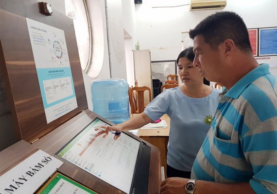 第一郡新定坊人委會幹部指引民眾通過 線上公共勞務辦手續。