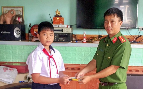 六年級學生高志源（左）將所拾到的款項轉交予當地公安派出所代表，以託尋找失主歸還。（圖源：慶福）