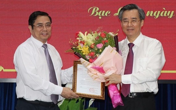 新任中央組織部副部長阮光陽（右）從中央組織部長范明正手中接過人事委任《決定》和祝賀鮮花。（圖源：越通社）