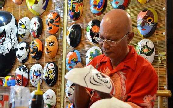 裴貴峰用心繪畫每一張面具。