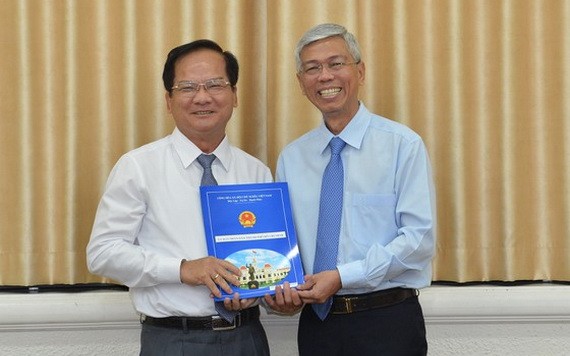 陳文勸同志（左）從市人委會副主席武文歡手中接過人事委任《決定》。（圖源：越勇）