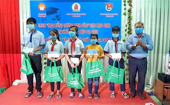 滀臻省越南祖國陣線委員會代表向落葉劑受害者的學生頒贈“梁定古”助學金和禮物。（圖源：忠孝）