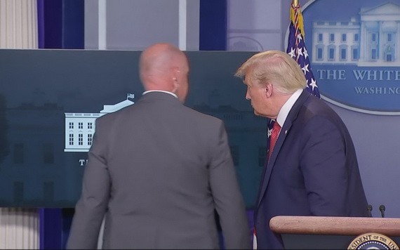 一名特勤人員走到台前與特朗普短暫交談後，護送特朗普離開。（圖源：視頻截圖）