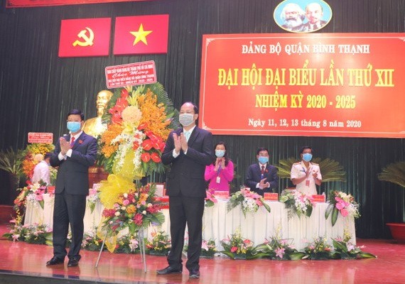 市委常務處委員、組織處主任阮胡海（前右）出席平盛郡黨部2020-2025年任期第十二次代表大會並贈送鮮花祝賀。（圖源：蔡芳）