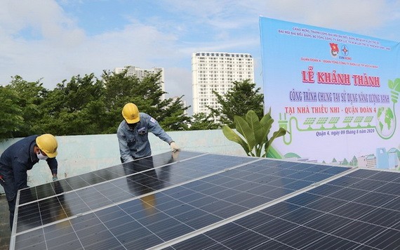 年輕電工正在第四郡少兒文化宮安裝屋頂太陽能光電板。