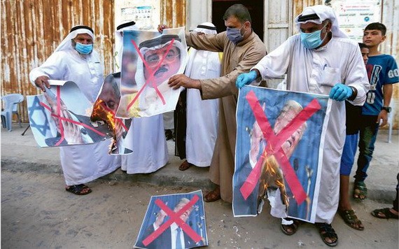 一批巴勒斯坦示威者焚燒美國總統特朗普、以色列總理內塔尼亞胡和巴林國王哈馬德的相片。（圖源：AFP）