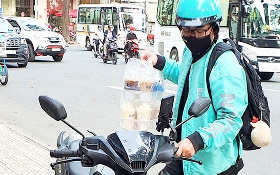 送貨員送一次性塑料杯裝的咖啡。